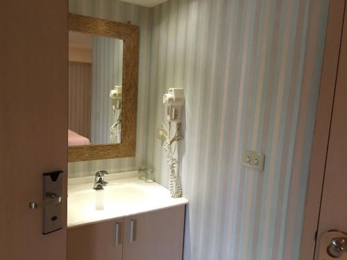 中和日晖商务旅馆的一间带水槽和镜子的浴室