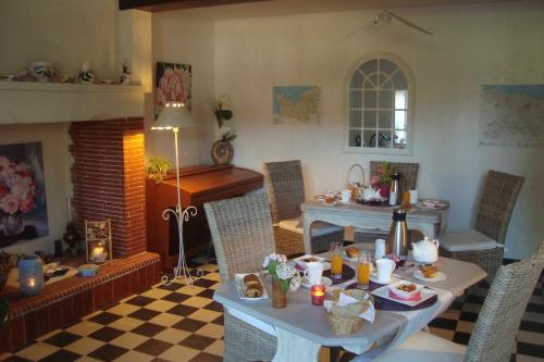 Sainte-Honorine-des-Pertes乐克洛斯圣让住宿加早餐旅馆的客厅配有桌子和壁炉