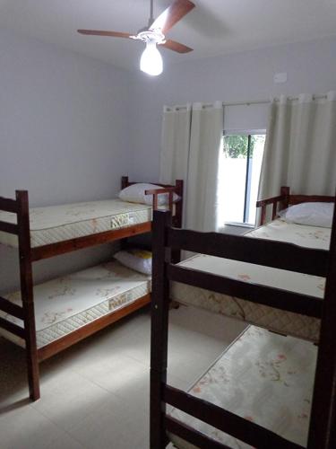 博尼图Casas para temporada em Bonito的客房设有三张双层床和吊扇。