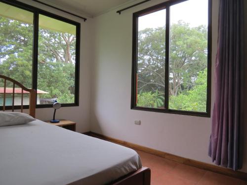 La GaritaQuinta Celeste的一间卧室配有床和两个树木窗户