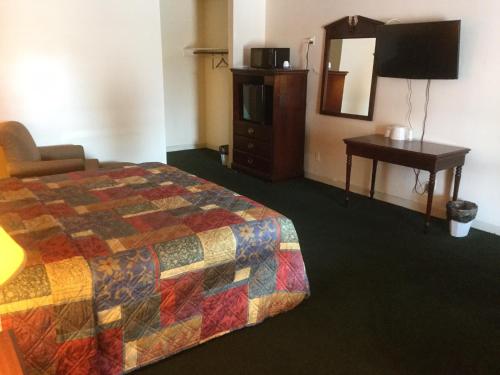 兰伯顿Budget inn的酒店客房设有床、梳妆台和镜子