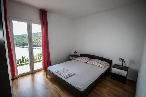莫鲁纳特Apartments Antunović的一间卧室设有一张床和一个大窗户