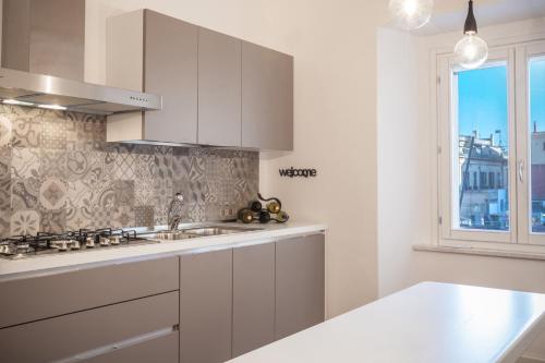 卡利亚里Arcipelago 41的白色的厨房设有水槽和窗户