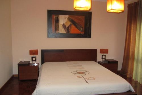 加亚新城Apartamento Superior Helena's Porto Corner的卧室配有一张床,墙上挂有绘画作品