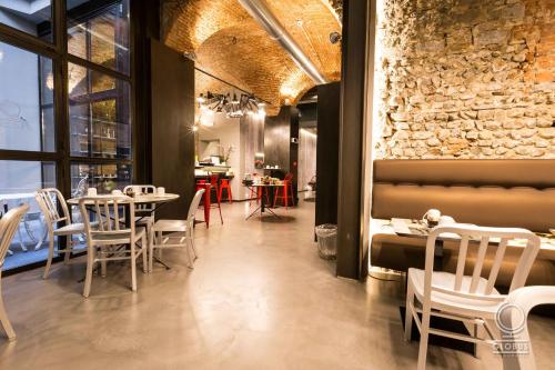 佛罗伦萨Globus Urban Hotel的一间带桌椅的餐厅以及砖墙