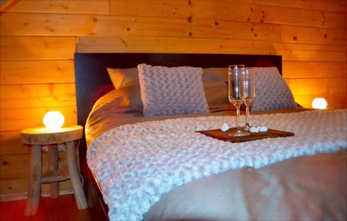 杜柏Chalet Montana - hot tub, sauna, playstation的一间卧室,配有一张带两杯眼镜的床