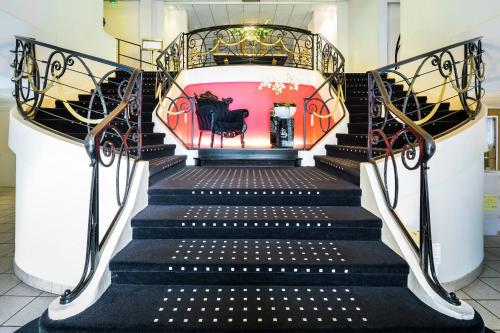 卢尔德卢尔德帝国美居酒店的楼梯有黑色的台阶和红色的墙壁