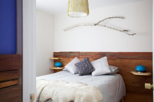 El Colorado比安科公寓式酒店的卧室配有白色的床和木制床头板