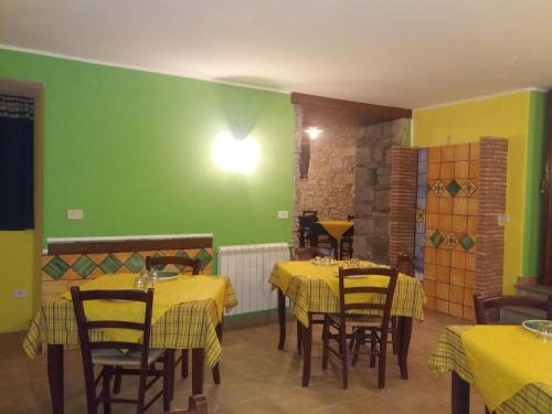FlorestaHotel Sant'Anna的餐厅设有黄色的桌椅和绿色的墙壁