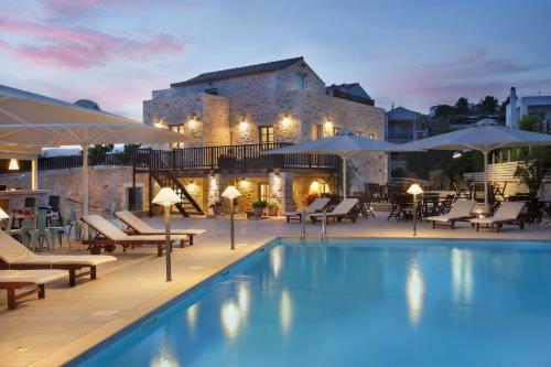 伊西翁提瑞迪斯比奇酒店的酒店游泳池设有椅子和遮阳伞,酒店大楼