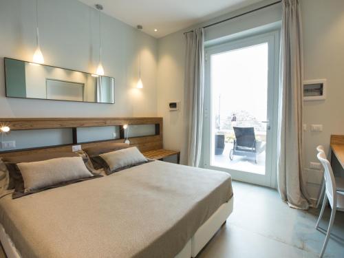 蒙特罗索阿尔马雷Roca Du Ma Pasu的一间卧室设有一张大床和一个大窗户