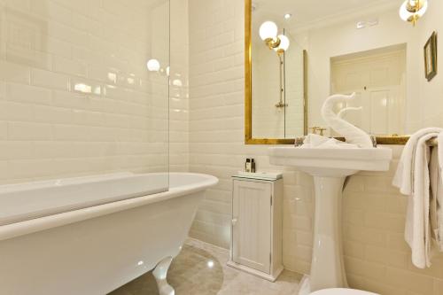 巴特米尔布里奇酒店的白色的浴室设有浴缸、水槽和浴缸。