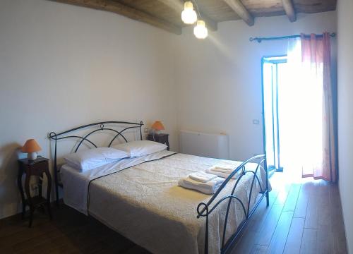Prignano CilentoB&B Il Giardino sull'Alento的一间卧室配有一张带两把椅子的床和一扇窗户