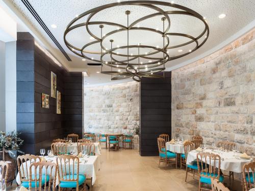 拿撒勒拿撒勒会议中心酒店的一间带桌椅和吊灯的用餐室