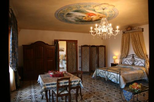 科里利亚诺多特兰托Calì Nitta的一间卧室配有一张床、一张桌子和一个吊灯。