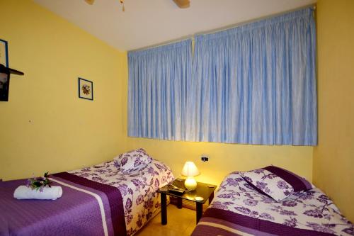 萨洛Apartamento en Salou的一间卧室设有两张床,窗户配有蓝色窗帘