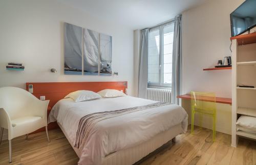 拉罗谢尔Hotel La Marine, Vieux Port的卧室配有床、椅子和窗户。