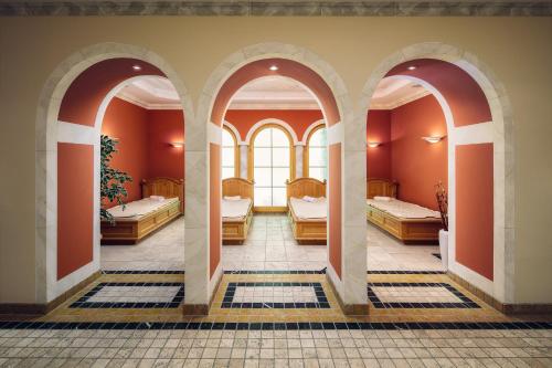 萨姆瑙恩恩加丁疗养酒店的带三张床和三扇窗户的房间