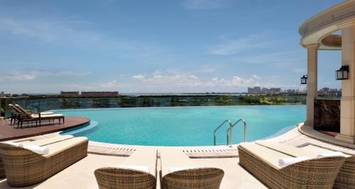 海口海口朗廷酒店的庭院内一个带藤椅的游泳池