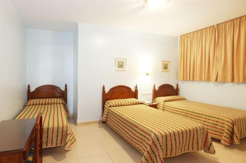 科尔多瓦锡斯内威尔蒂酒店的一间卧室配有两张床和一张桌子