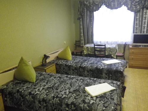 文茨皮尔斯Strādnieku viesnīca的酒店客房设有两张床和窗户。