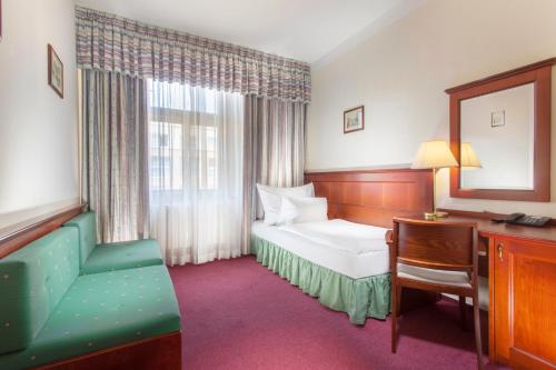 布拉格鲁尼克酒店的酒店客房配有一张床、一张桌子和一把椅子。