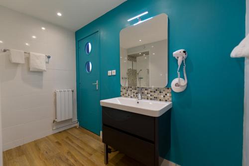 波尔多Citotel Le Regina Bordeaux Gare Saint-Jean的一间带水槽和蓝色墙壁的浴室