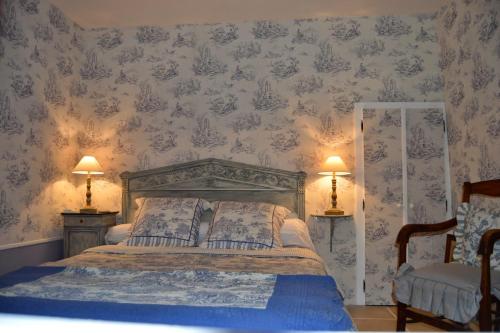 勒布朗Haut du Blanc的一间卧室配有一张带两盏灯和两把椅子的床。