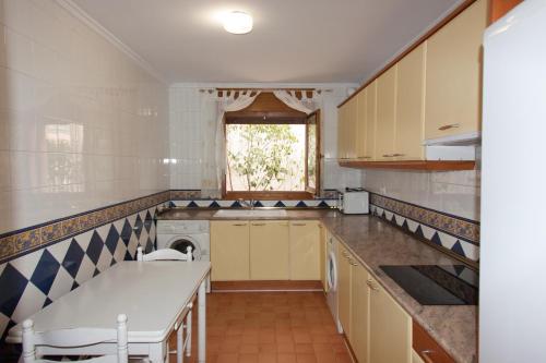 阿尔巴拉辛Apartamentos Río Guadalaviar的厨房设有黄色橱柜和窗户。