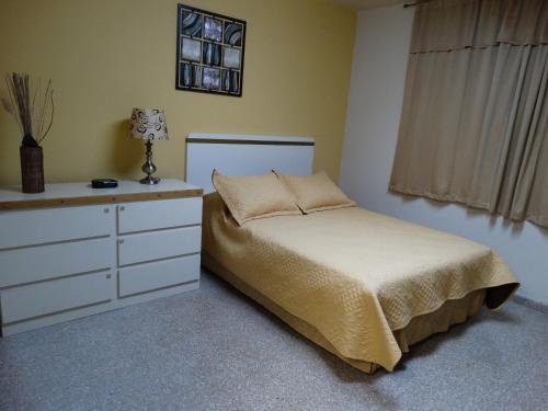圣赫尔曼Hostal Universitario的卧室配有白色的床和梳妆台。