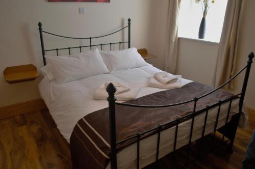 道格拉斯Sea Breeze Guest House的一间卧室配有带白色床单和枕头的床。