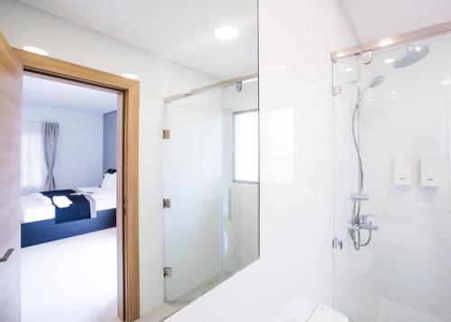 阿布贾Nordic Hotel Abuja的带淋浴和卫生间的浴室以及一间卧室。