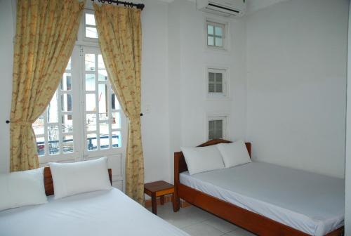 顺化拉姆东天大酒店的带窗户的客房内的两张床