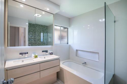 努萨维尔努萨河畔度假酒店的一间带水槽、浴缸和镜子的浴室