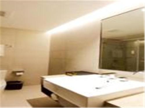 济南如家快捷酒店济南堤口路火车站北广场店的浴室设有白色水槽和镜子