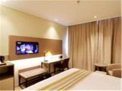 济南如家快捷酒店济南解放路店的酒店客房设有一张床和墙上的电视