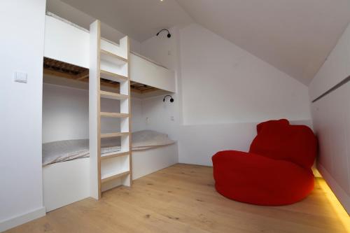 根特Stay in Ghent的一张红色椅子,位于带双层床的房间