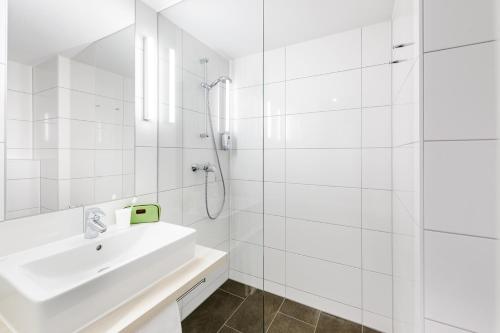 康斯坦茨康斯坦茨宜必思经济酒店的白色的浴室设有水槽和淋浴。