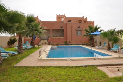 Al Medou达尔埃尔菲达欧斯旅馆的棕榈树屋前的游泳池