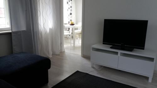 库奥皮奥Apartment Vuorikatu 35的客厅配有白色橱柜上的平面电视