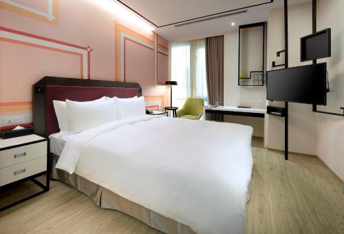台北悠逸商旅台北士林的酒店客房设有一张白色大床和一张书桌