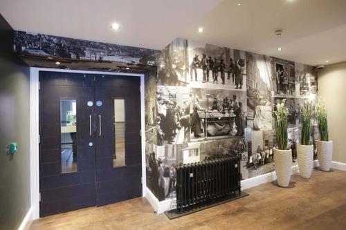 惠特比威瑟斯本安琪尔酒店的走廊上挂有照片的墙壁