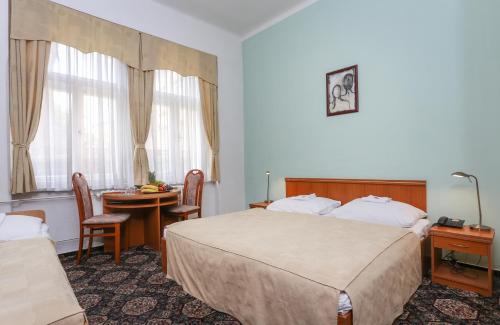布拉格布拉格城市俱乐部酒店的酒店客房设有两张床和一张桌子。