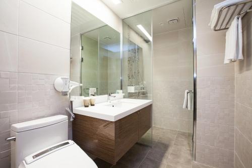 西归浦市尤尔斯酒店的一间带水槽、卫生间和镜子的浴室