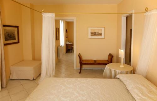 马里纳-迪-皮特拉桑塔Villa Amelia Rooms的一间卧室配有一张床、一把椅子和一张桌子