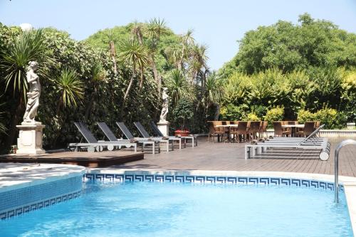 罗列特海岸Augusta Club & Spa - Adults Only的一个带躺椅和桌子的游泳池以及游泳池