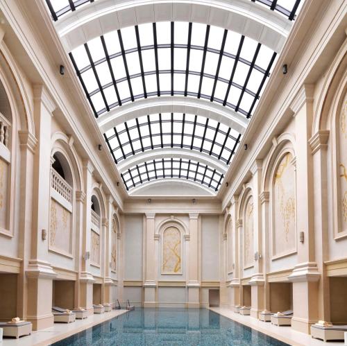 巴库巴库四季酒店的享有带玻璃天花板的大楼内的游泳池景致