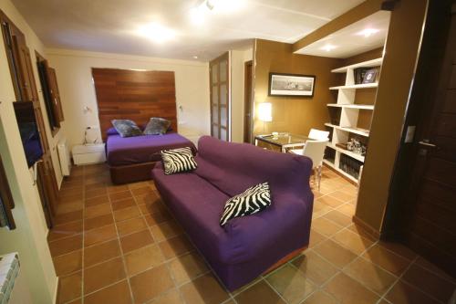 昆卡Apartamentos Casas Colgadas的客厅配有紫色沙发和床。