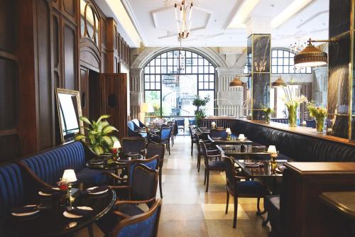 雅加达古纳瓦尔曼酒店 的一间在房间内配有桌椅的餐厅