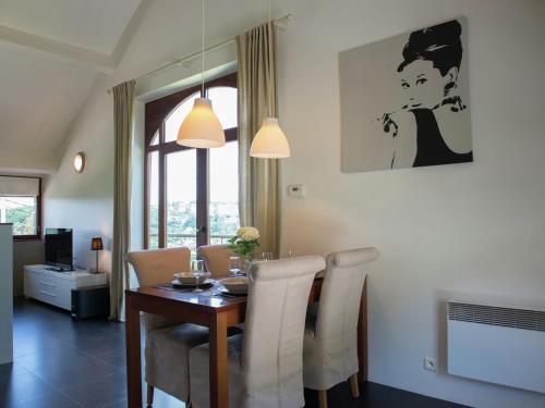 马尔梅迪Luxury Apartment in Malmedy with bubble bath的一间带桌椅的用餐室和一间带窗户的房间